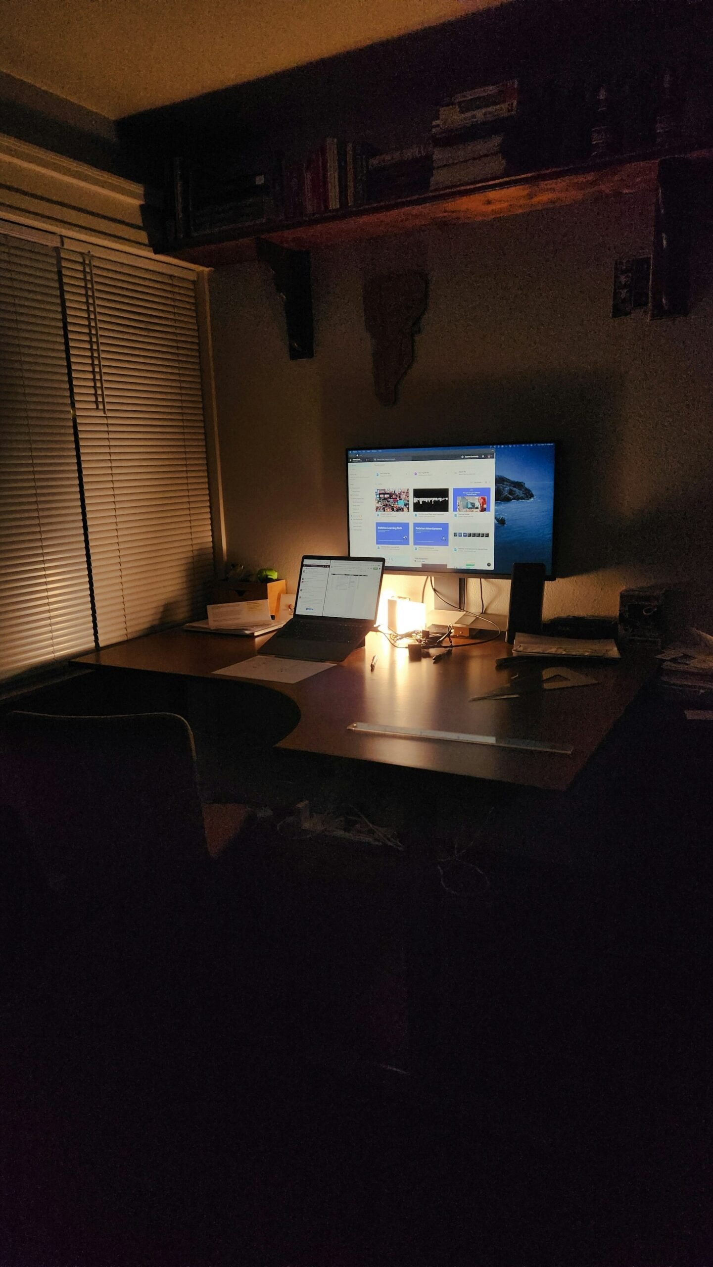 Moody solo workspace with laptop and monitor at night
